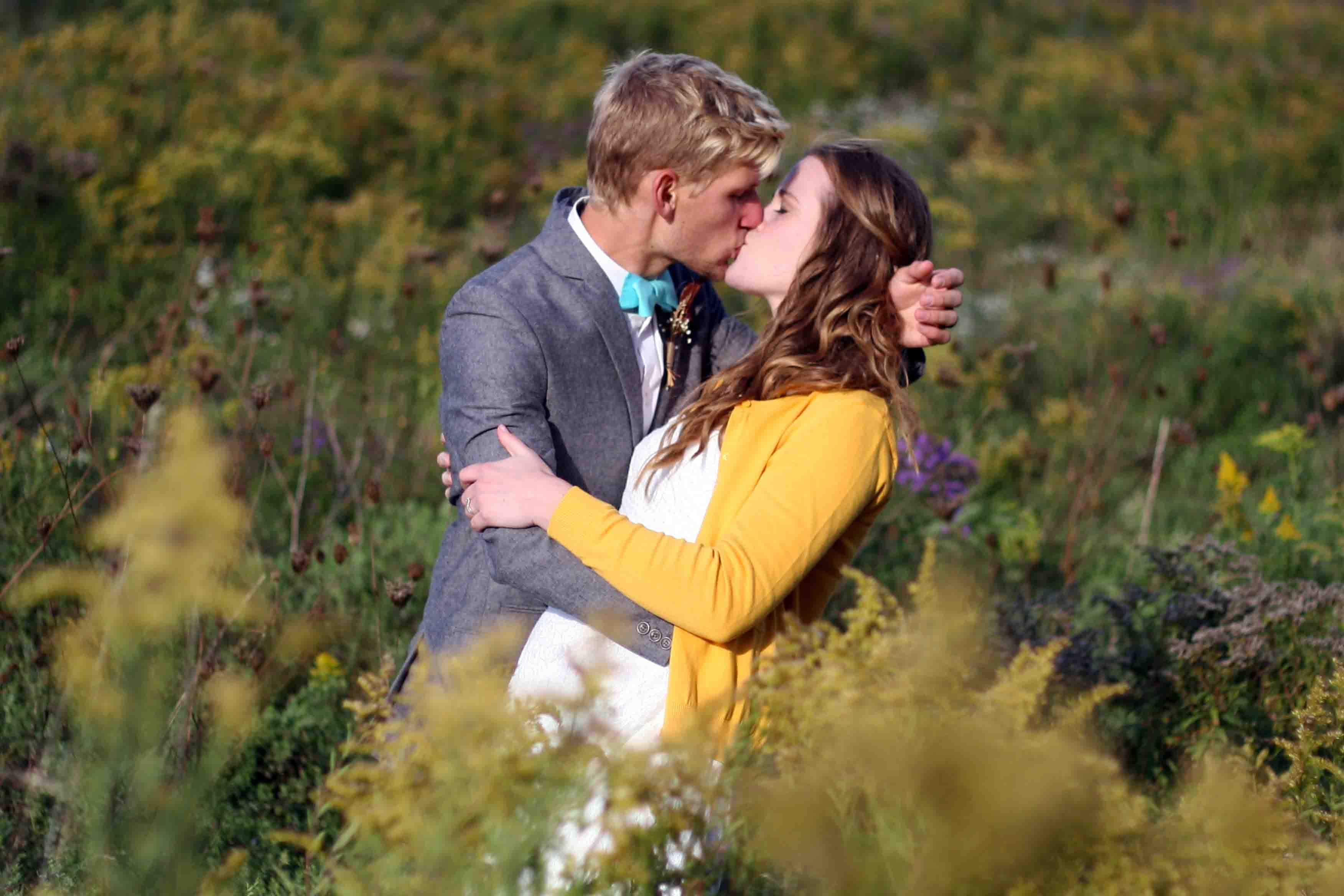 Greg and Karen kissing in long grass
