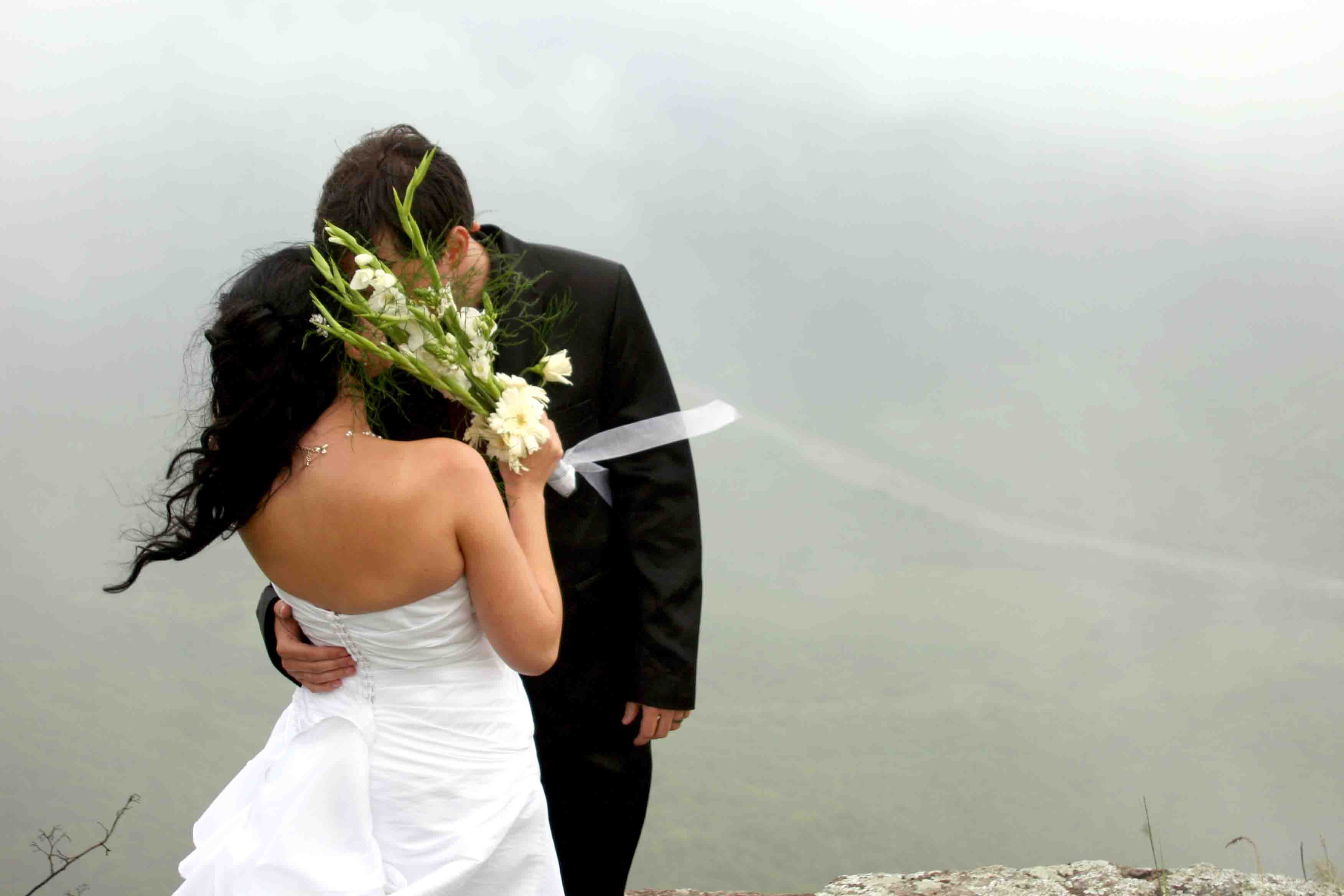 Jason and Jess kissing on the edge of a cliff